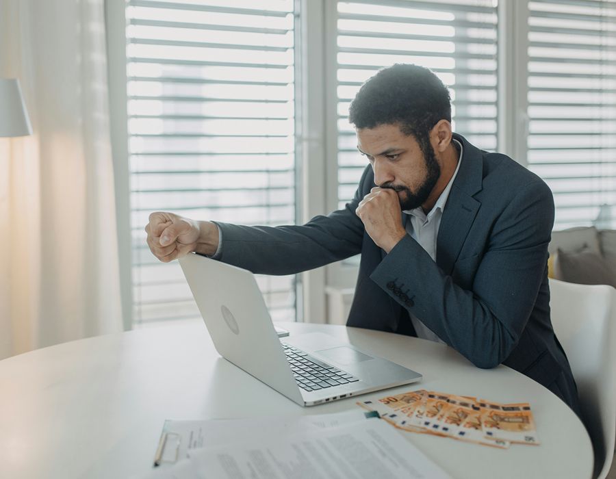 Distressed man looking at a laptop after an IRS wage garnishment.